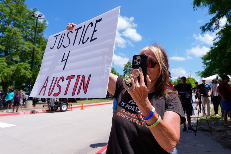 An Austin Metcalf supporter holds a sign in front of the Collin County courthouse after the verdict was reached in the Karmelo Anthony trial.