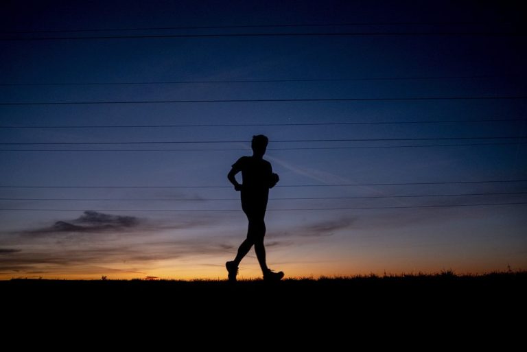 A man runs on a small road.