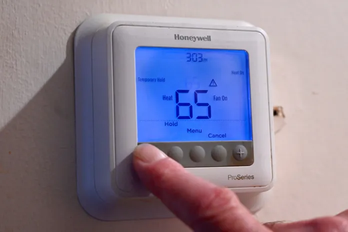 Mark Bain sets his thermostat to 65 degrees