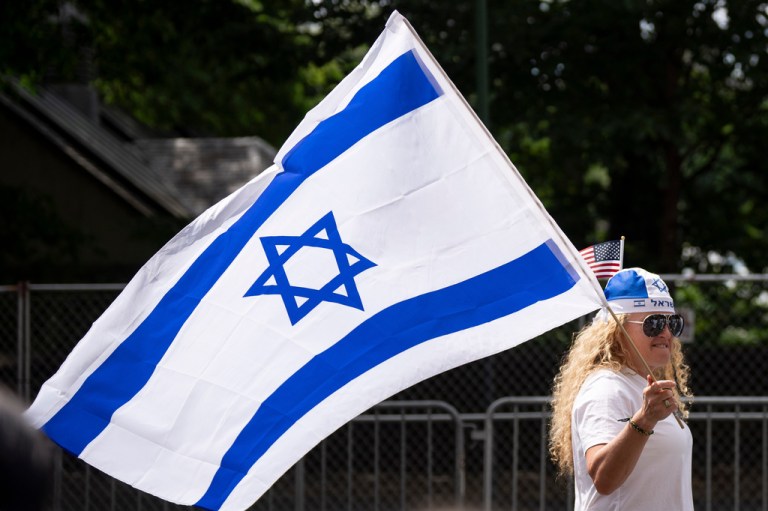 A woman holds an Israeli flag while walking down Fifth Avenue during the Israel Day Parade, Sunday, May 31, 2026, in New York.