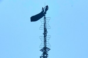 Two people climb to top of Empire State Building with flag