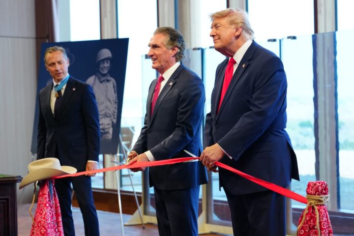President Donald Trump and Interior Secretary Doug Burgum cut a ribbon during a ceremony presenting Theodore Roosevelt's Medal of Honor at the Theodore Roosevelt Presidential Library.