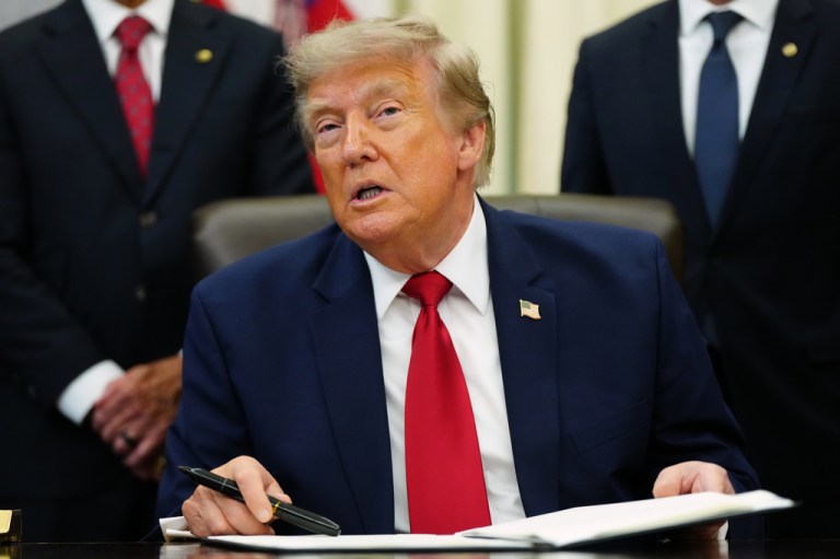 President Donald Trump sitting at the Oval Office desk