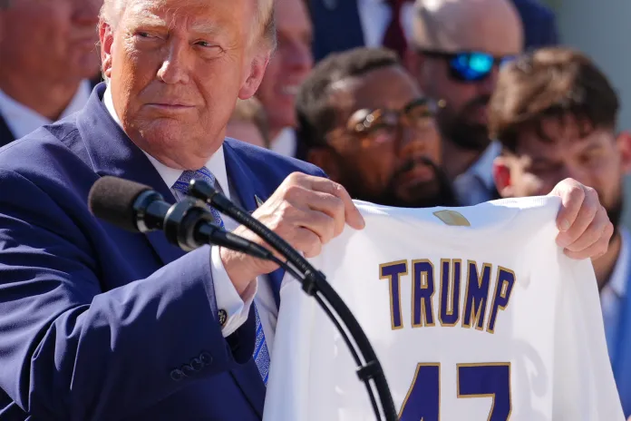 Trump holds up a Dodgers jersey with his name on it.