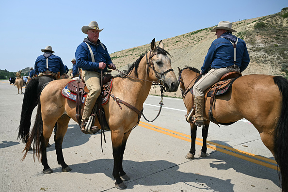 Rough Riders reenactors, portraying the 1st United States Volunteer Cavalry, ride horses ahead of US President Donald Trump's motorcade.