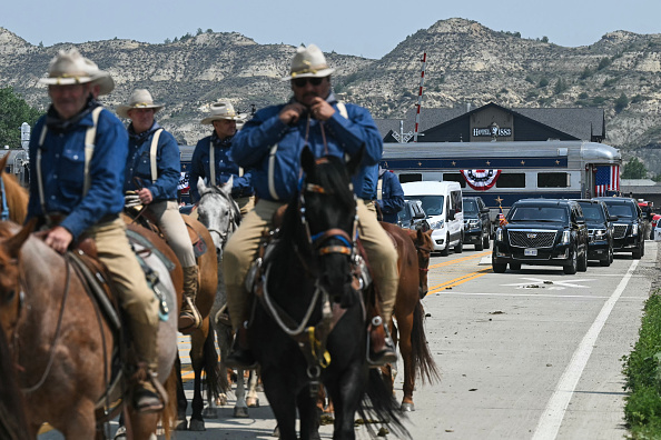 Rough Riders reenactors, portraying the 1st United States Volunteer Cavalry, ride horses ahead of US President Donald Trump's motorcade.