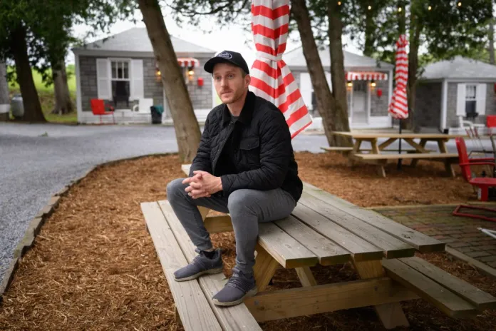 Kyle Brown, co-owner of the Lincoln Motor Court, sits outside the historic roadside motel