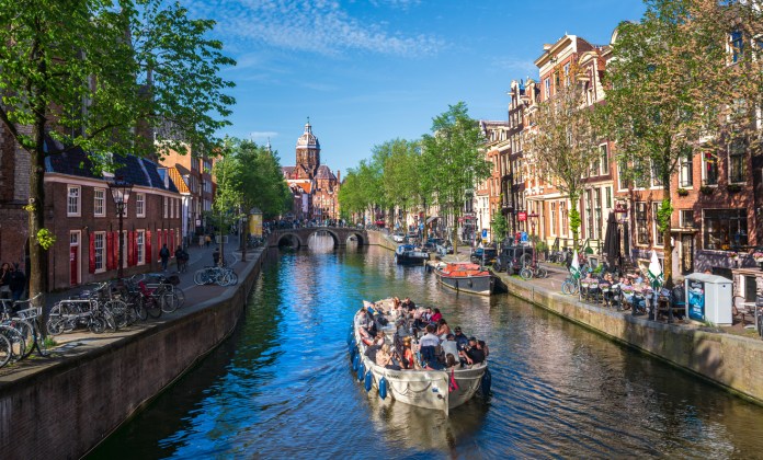 Tourists take a scenic boat cruise along the historic Oudezijds Voorburgwal Canal in Amsterdam, Netherlands on May 26, 2026. (Getty Images) 