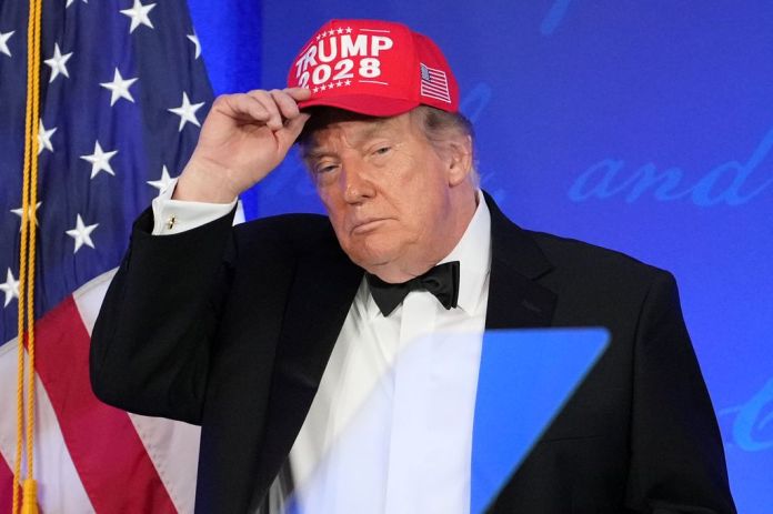 Trump puts on a "Trump 2028" hat.