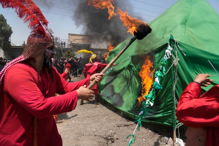 Men burn a tent in Tehran, Iran, Thursday, June 25, 2026, while re-enacting the enemies of Imam Hussein in the battle of Karbala in A.D. 680 in present-day Iraq, in which the Imam, a grandson of the Prophet Muhammad, one of Shiite Islam's most beloved saints, and his family and companions were killed after refusing to pledge allegiance to the Umayyad caliphate. (AP Photo/Vahid Salemi)