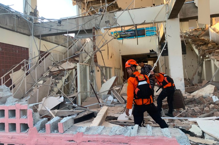 Rescuers search for victims at a damaged building following an earthquake in Maumere, East Nusa Tenggara Province, Indonesia.