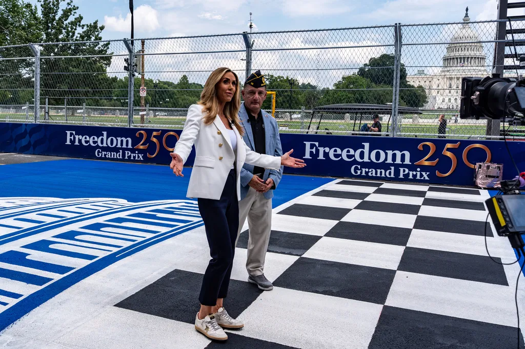 Lara Trump, left, and Mario Marquez, the Executive Director of Government Affairs for the American Legion, record a tv segment on the finish line painted on 3rd Street with the U.S. Capitol in the background ahead of the Freedom 250 Grand Prix, Thursday, Aug. 20, 2026, in Washington. (AP Photo/Alex Brandon)