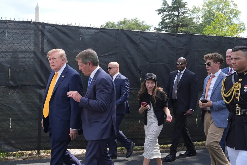 Trump walks with the governor of Nebraska and guests.