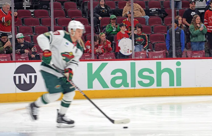 The National Hockey League’s Minnesota Wild warms up in front of a sign advertising the prediction market platform Kalshi in Chicago before a game against the Chicago Blackhawks, March 17, 2026. (David Banks/AP)