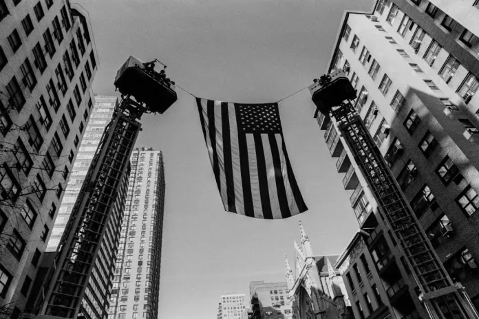 An American flag hoisted high during a funeral for a New York City firefighter who was killed during the 9/11 terrorist attacks.