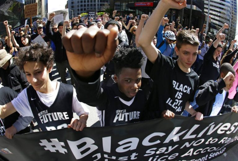 Protesters make the raised-fist "Black Power" sign.