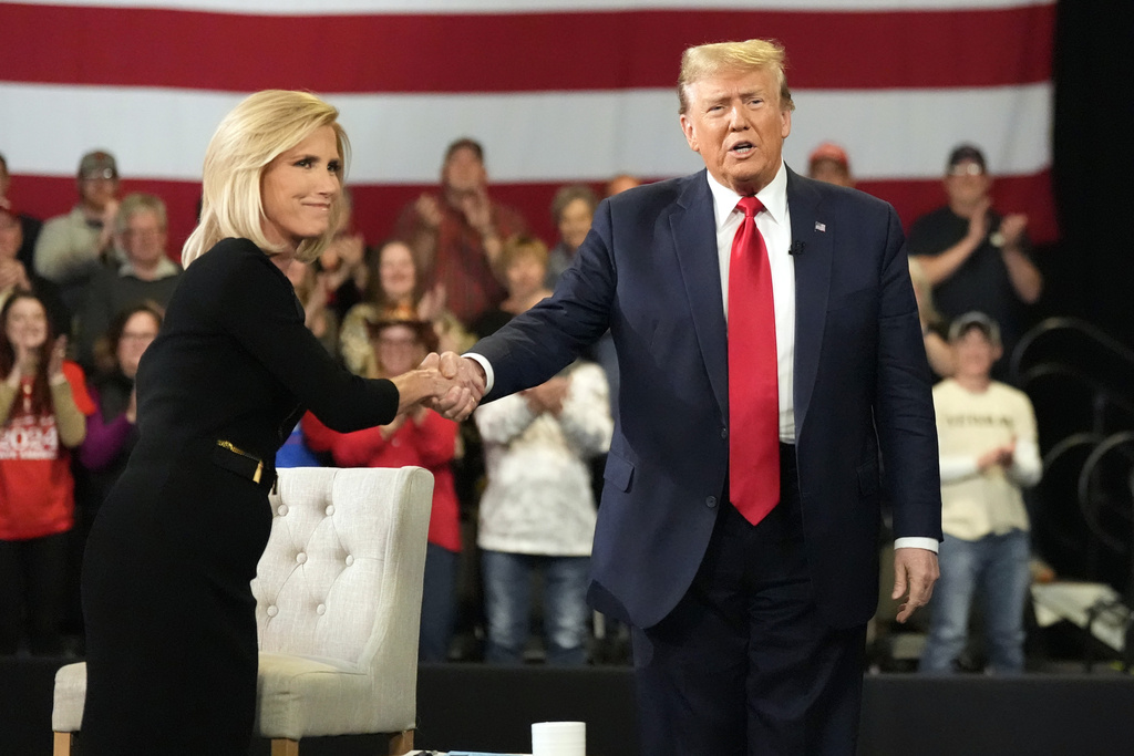 Republican presidential candidate former President Donald Trump greets moderator Laura Ingraham at a Fox News Channel town Hall Tuesday, Feb. 20, 2024, in Greenville, S.C. (AP Photo/Chris Carlson)