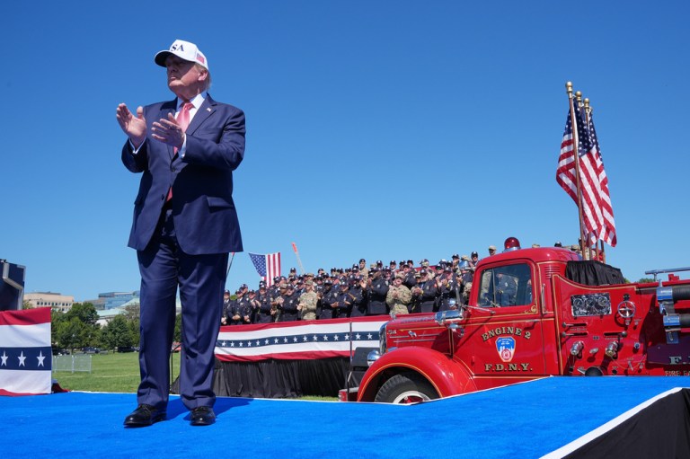 President Donald Trump claps after speaking