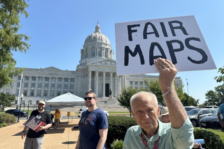 This photo taken with a smartphone shows Steve Perry, of Kansas City, holding a sign in opposition to Missouri’s congressional redistricting plan.