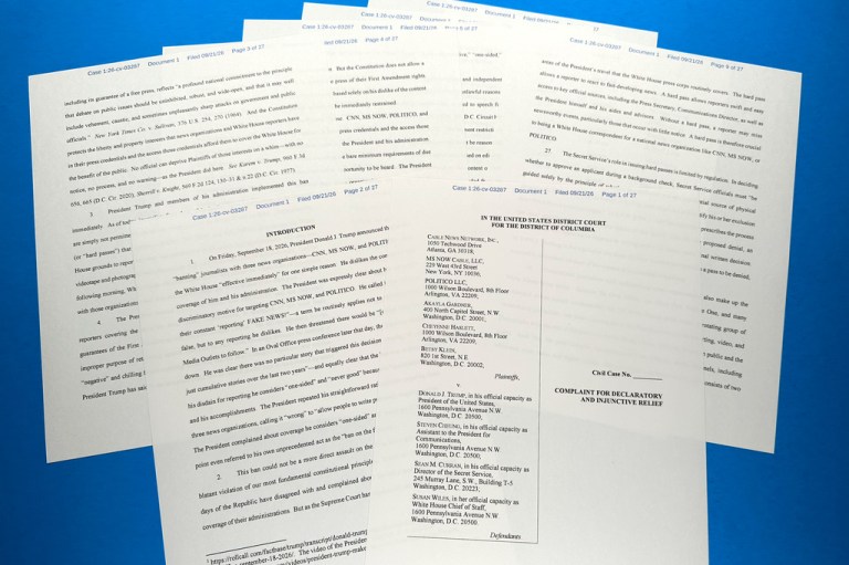 The lawsuit filed by CNN, MS NOW and Politico against the administration of U.S. President Donald Trump is photographed on a table.