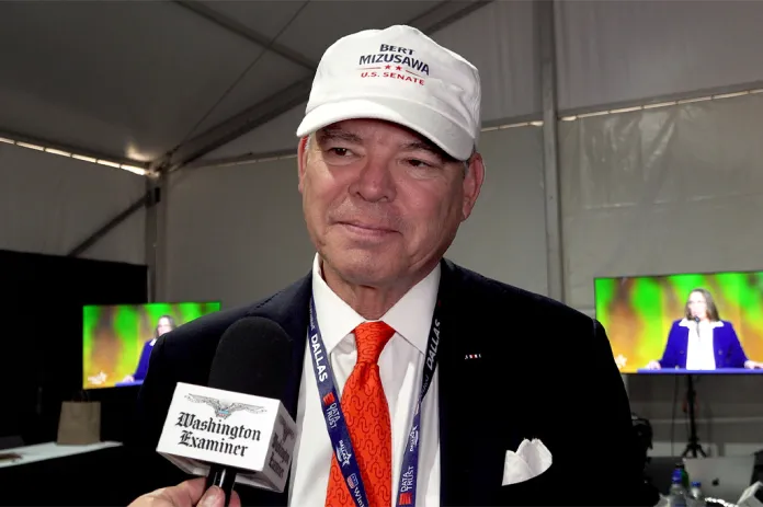 Man smiling into microphone with Washington Examiner logo