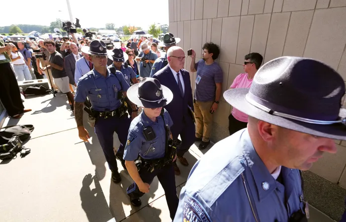 Police escort District Attorney for Plymouth County Timothy Cruz, center, after the judge declared a mistrial in Lindsay Clancy’s murder trial on Sept. 4, 2026, in Plymouth, Massaschusetts. (Charles Krupa/AP)
