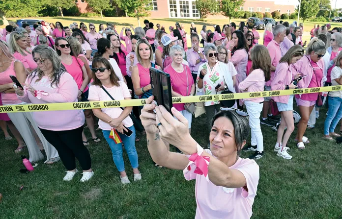 Aimee Breault of Acushnet, Massachusetts, livestreams a demonstration in support of Lindsay Clancy outside Plymouth Superior Court, where Clancy is on trial in connection with the deaths of her three children, on Aug. 20, 2026. (Josh Reynolds/AP)