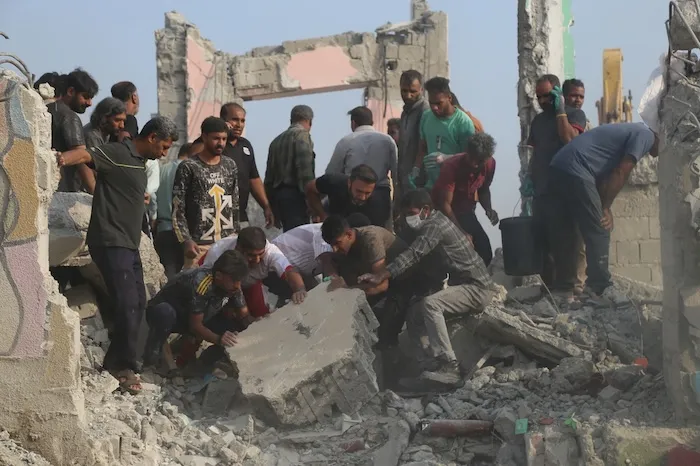 Rescue workers and residents search through the rubble in the aftermath of a strike on a primary school in Minab, Iran