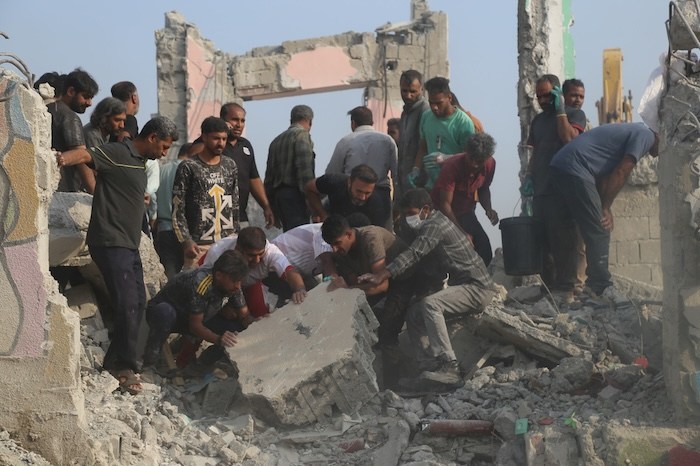 Rescue workers and residents search through the rubble in the aftermath of a strike on a primary school in Minab, Iran
