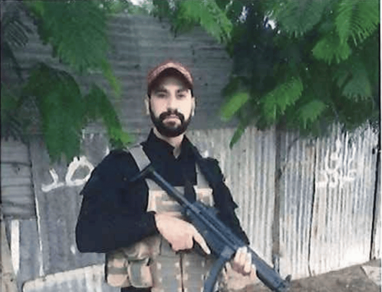 Mahmoud Amin Ya’qub al Muhtadi holding a gun.