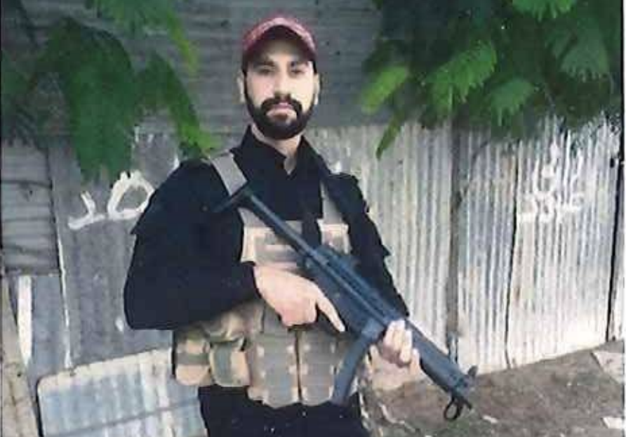 A photo shows Mahmoud Amin Ya’qub Al-Muhtadi with a gun connecting him to the Hamas-supporting National Resistance Brigade, according to federal prosecutors. (Image credit: Department of Justice)