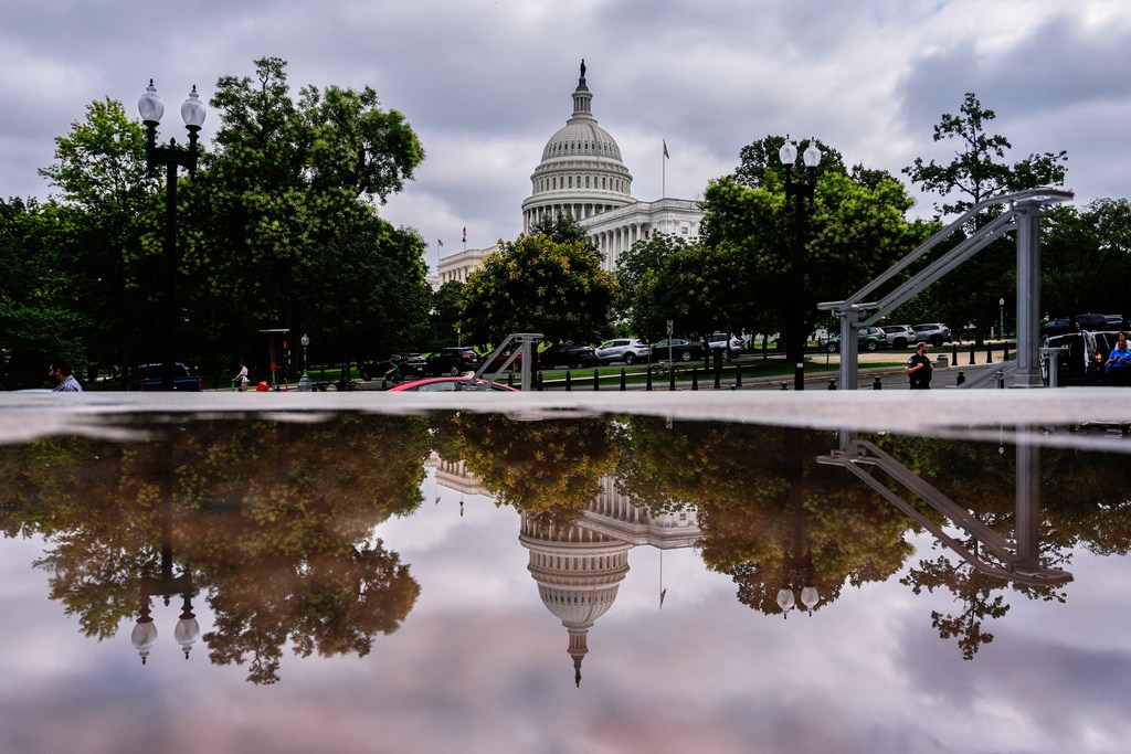 The U.S. Capitol is reflected in a puddle outside of the Rayburn House Office Building, Wednesday, July 16, 2025, on Capitol Hill in Washington. (AP Photo/Julia Demaree Nikhinson)