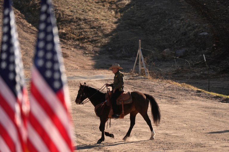 A member of the U.S. Border Patrol rides a horse near the U.S. and Mexico border wall prior to Kristi Noem, Secretary of the Department of Homeland Security, speaking at an event there, Wednesday, Feb. 4, 2026, in Nogales, Ariz.