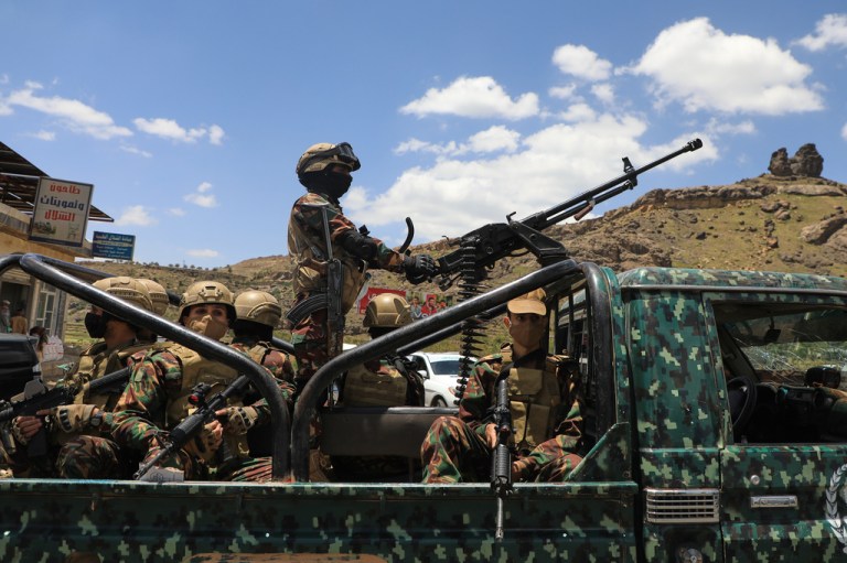 Houthi fighters escort a convoy carrying prisoners freed in Mokha through the Bani Matar district on its way to Sanaa, Yemen.