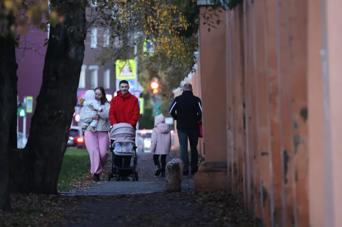 People walk past the fence of the building of the Irkutsk Anti-Plague Research Institute of Siberia and the Far East.