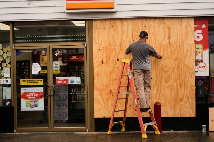 Jason Coffey boards up a convenience store at a gas station as Hurricane Isaias approaches Pensacola Beach, Fla., Friday, Oct. 9, 2026.