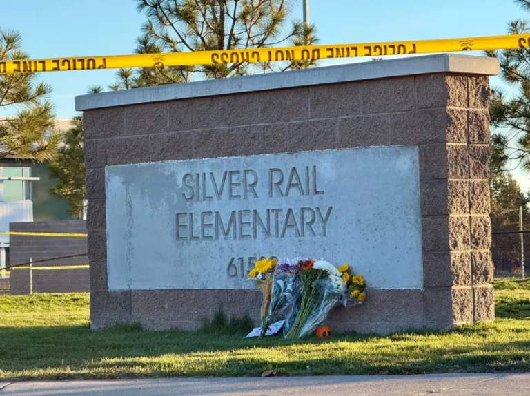 Flowers are placed beside a sign at Silver Rail Elementary School in Bend, Oregon, a day after a deadly shooting.