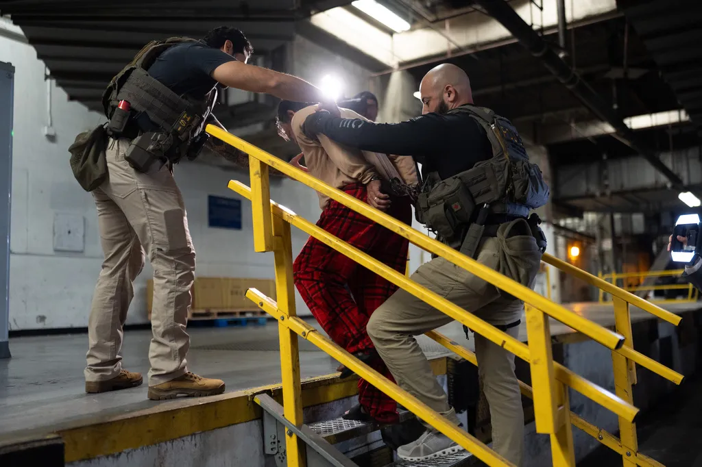 Homeland Security Investigations task force officers escort a suspect accused of illegally registering to vote to a processing facility at Federal Building in Los Angeles, Monday, Oct. 19, 2026.
