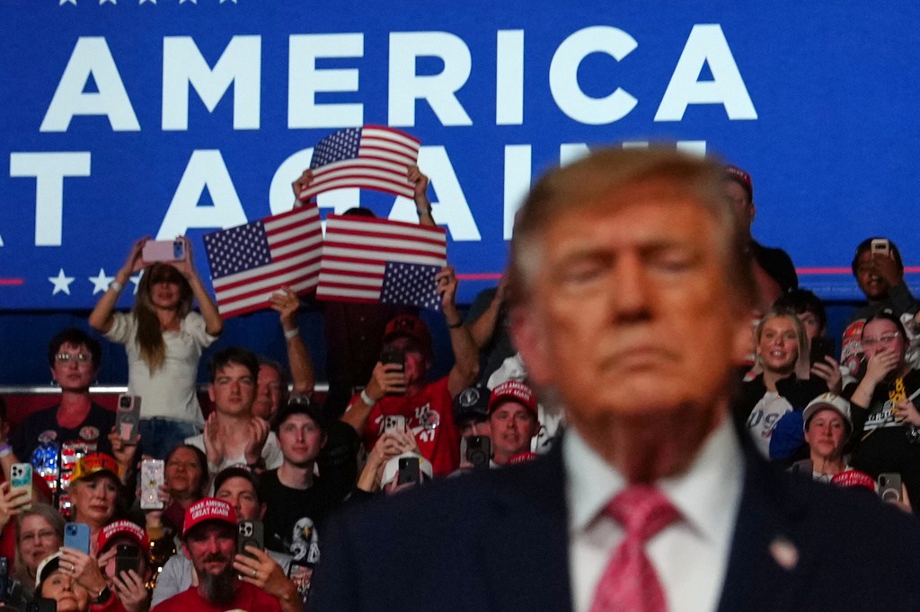People cheer as President Donald Trump speaks at a campaign rally.