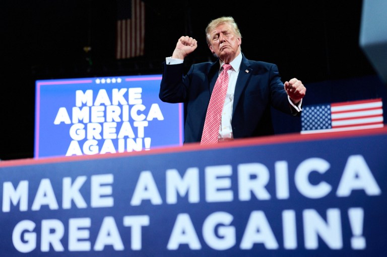 President Donald Trump at campaign rally with Make America Great Again signs.