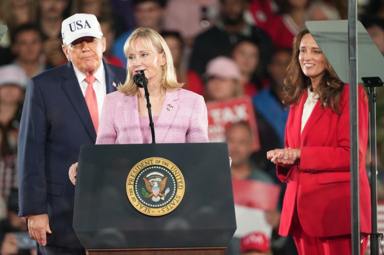 President Donald Trump and House candidate Jennifer Balkcom listen as House candidate Laurie Buckhout speaks at a campaign rally at PittGreenville Airport, Tuesday, Oct. 20, 2026, in Greenville, N.C. (AP Photo/Matt Ramey)
