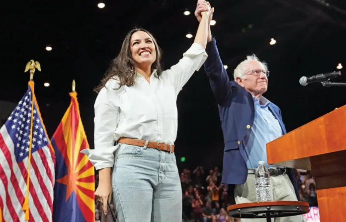 Ocasio-Cortez with Sen. Bernie Sanders (I-VT) on their ‘Fighting Oligarchy’ tour in Tempe, Arizona, March 20, 2025. (Ross D. Franklin/AP)