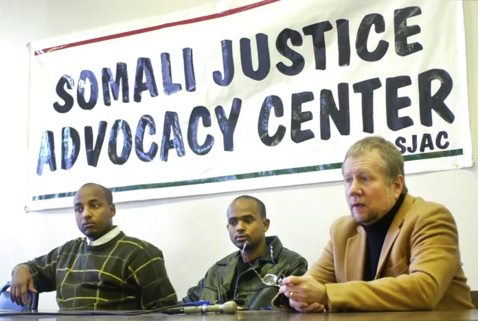 Ilyas Ahmed, center, is flanked by Omar Jamal, an area Somali legal advocate, and Peter Erlinder, a professor of constitutional criminal law, at a press conference in St. Paul, Minn., Tuesday. Feb. 4, 2003, where Ahmed described his detainment by the Immigration Naturalization Service. Ahmed was picked up at his home in Vadnais Heights in November 2002 and held in a Louisiana jail until Jan. 31, 2003. (AP Photo/Janet Hostetter)